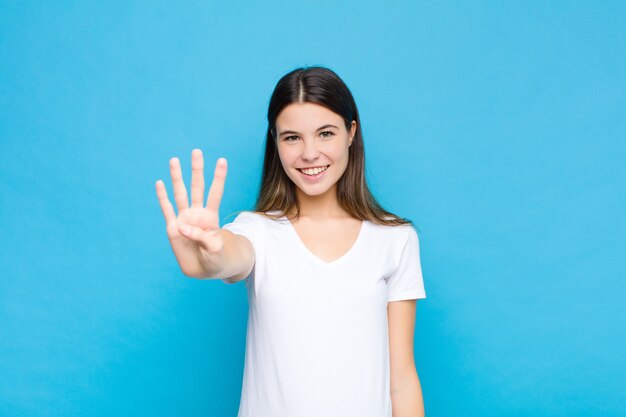 sonriendo y luciendo amigable, mostrando el número cuatro o cuarto con la mano hacia adelante, contando hacia atrás