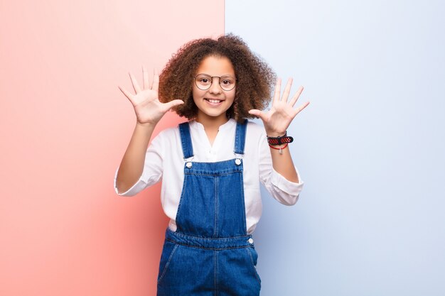 sonriendo y luciendo amigable, mostrando el número diez o décimo con la mano hacia adelante, contando hacia atrás