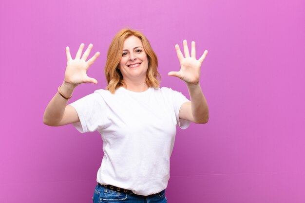 sonriendo y luciendo amigable, mostrando el número diez o décimo con la mano hacia adelante, contando hacia atrás