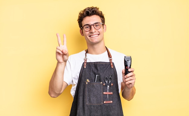 Sonriendo y luciendo amigable, mostrando el número dos o segundo con la mano hacia adelante, contando hacia atrás. concepto de barbero