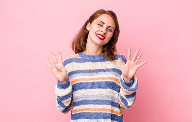 Sonriendo y luciendo amigable mostrando el número nueve o noveno con la mano hacia adelante contando hacia atrás