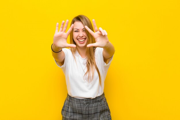 sonriendo y luciendo amigable, mostrando el número ocho u octavo con la mano hacia adelante, contando hacia atrás