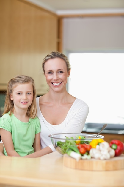 Sonriendo madre e hija en la cocina