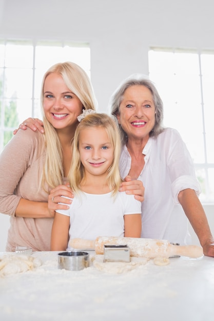 Sonriendo madres e hijas cocinar juntos