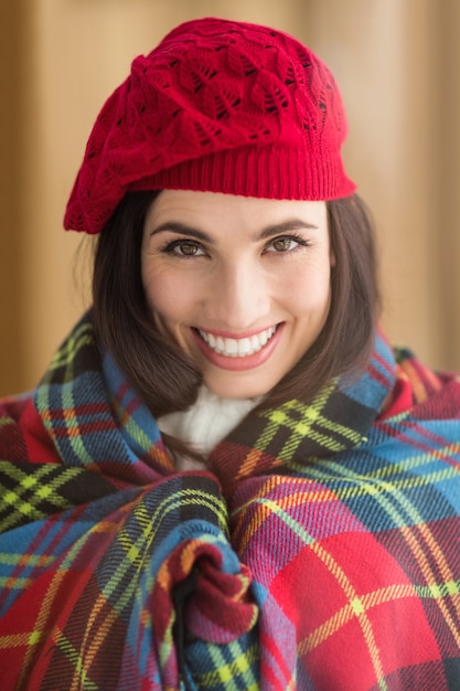 Sonriendo morena con tapa y sombrero rojo