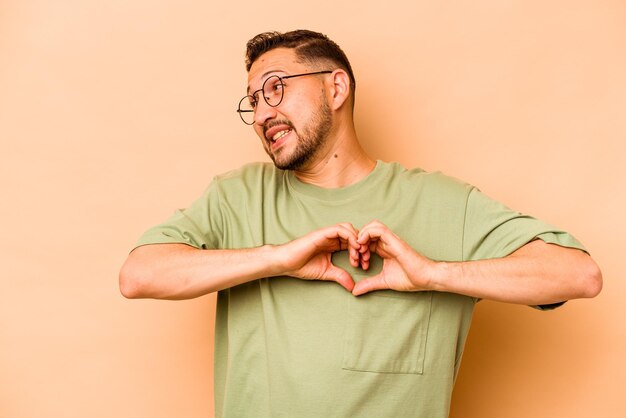 Sonriendo y mostrando una forma de corazón con las manos.