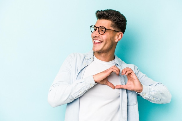 Sonriendo y mostrando una forma de corazón con las manos.