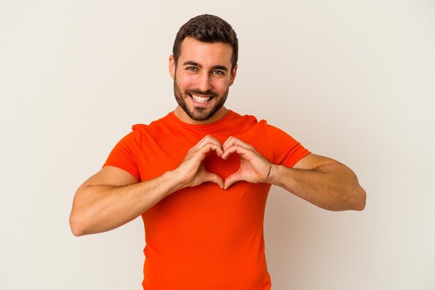 Sonriendo y mostrando una forma de corazón con las manos.