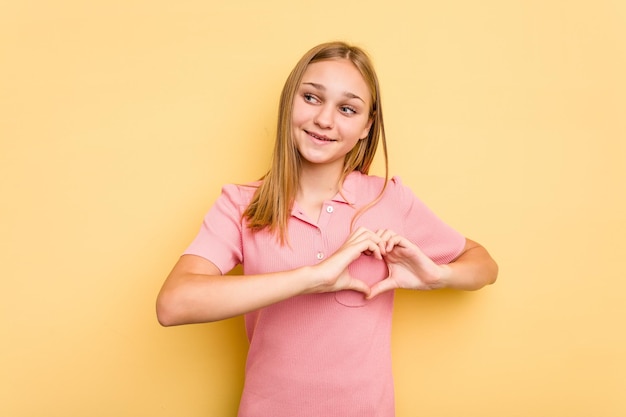 Sonriendo y mostrando una forma de corazón con las manos.