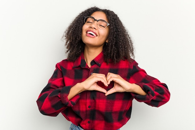 Sonriendo y mostrando una forma de corazón con las manos.