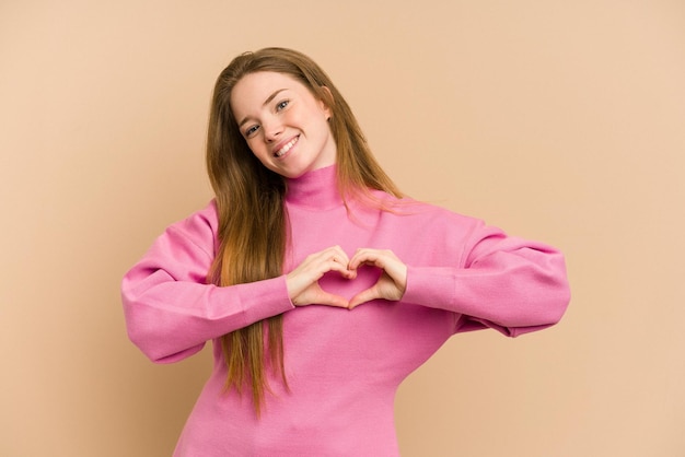 Sonriendo y mostrando una forma de corazón con las manos.