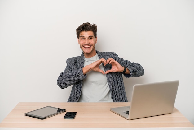 Sonriendo y mostrando una forma de corazón con las manos.