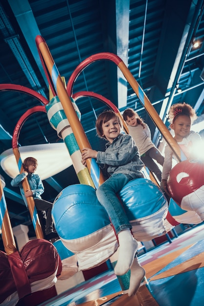 Sonriendo niños pequeños disfrutando de carrusel de equitación