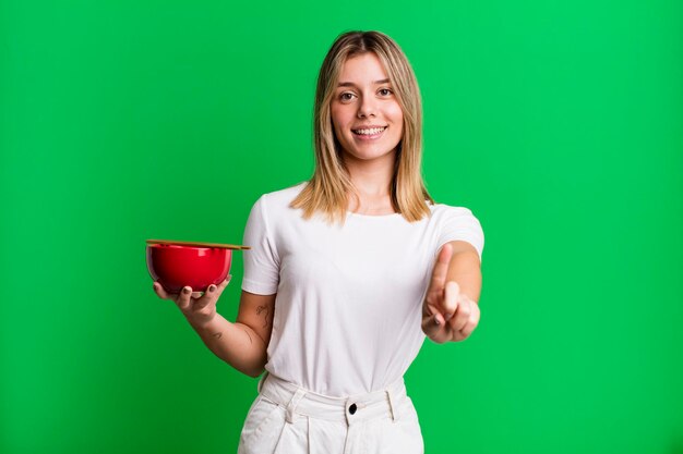 sonriendo con orgullo y confianza haciendo el número uno