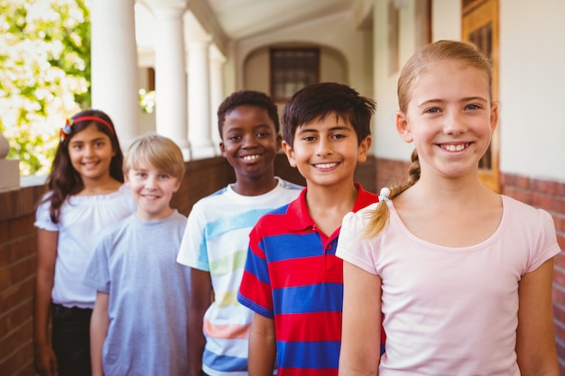 Sonriendo pequeños niños de la escuela en el pasillo de la escuela