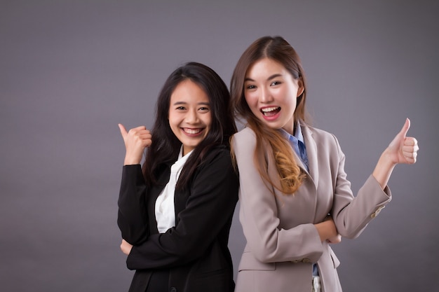 Sonriendo riendo exitoso equipo de negocios dando pulgar hacia arriba gesto