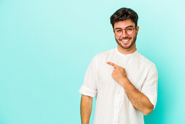 Sonriendo y señalando a un lado mostrando algo en el espacio en blanco