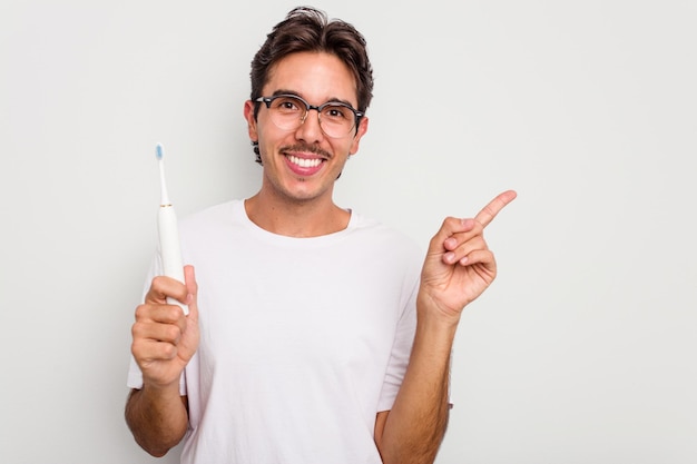 Sonriendo y señalando a un lado mostrando algo en el espacio en blanco