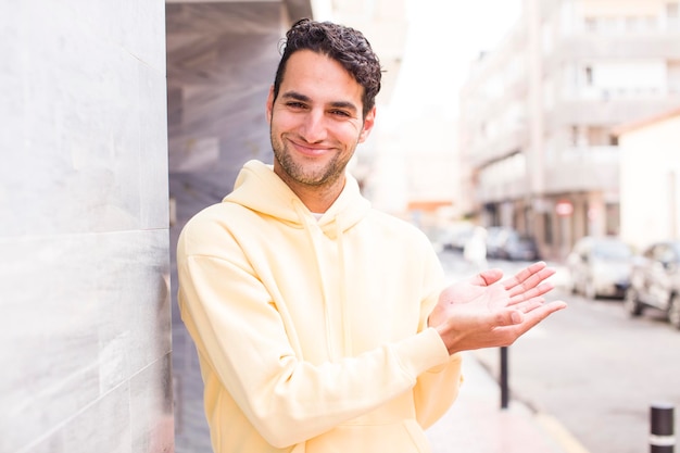 sonriendo sintiéndose confiado exitoso y feliz mostrando concepto o idea en espacio de copia en el lateral