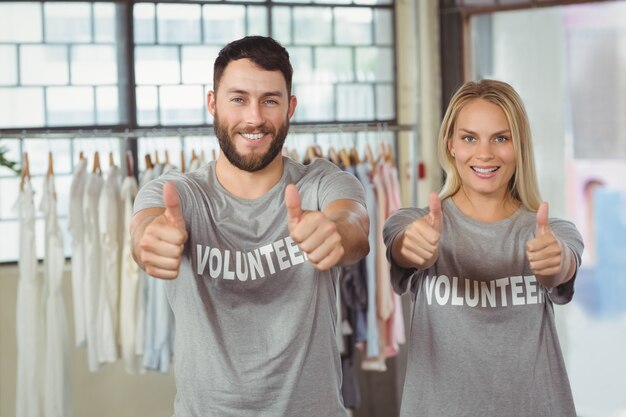 Sonriendo voluntarios dando pulgares arriba