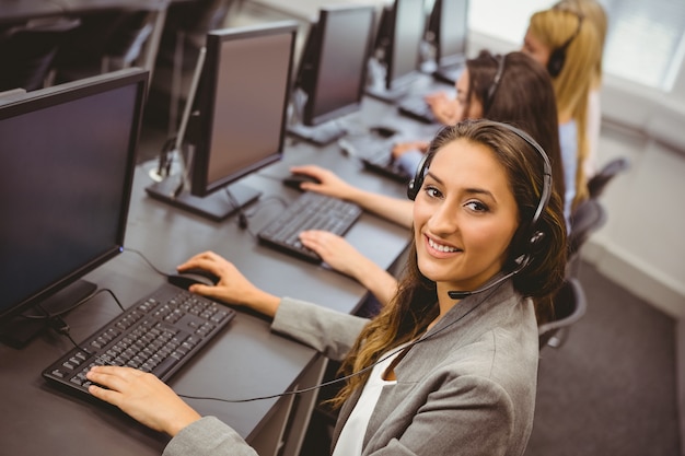 Sonriente agente de call center hablando por el auricular