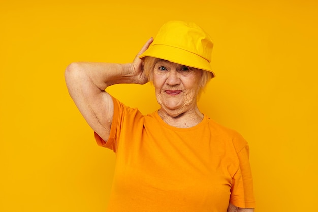 Sonriente anciana estilo de vida feliz en un tocado amarillo fondo amarillo