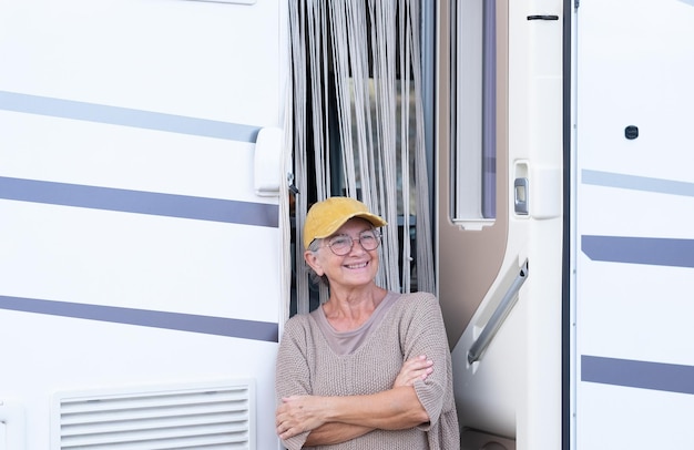 Sonriente anciana en vacaciones de viaje con una autocaravana disfrutando de un estilo de vida alternativo