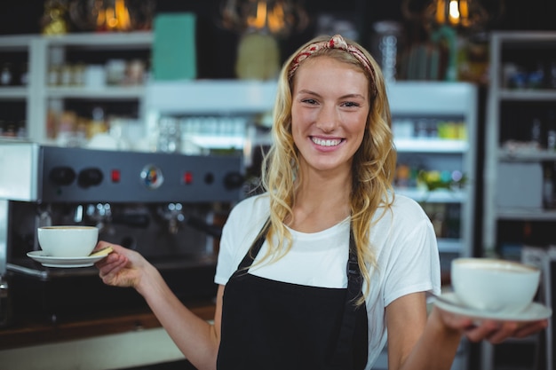 sonriente camarera ofreciendo una taza de café