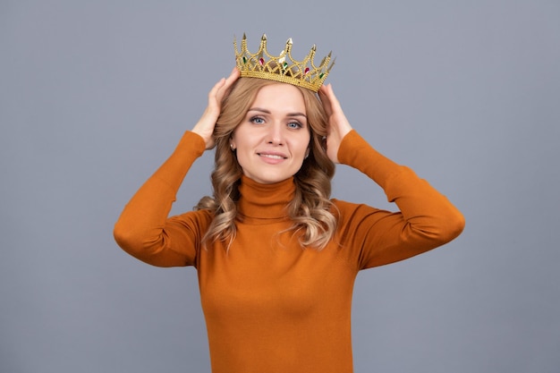 Sonriente chica rubia con corona de pelo rizado, egoísmo.