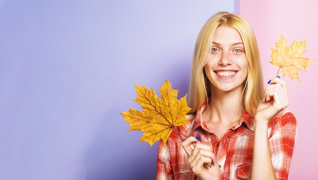 Sonriente chica rubia con hoja de arce otoño moda estado de ánimo otoñal moda mujer en camisa a cuadros
