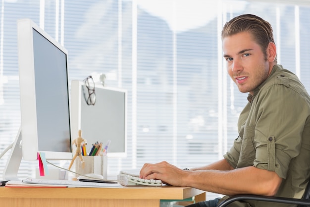 Foto sonriente empleado de negocios creativos que trabajan en la computadora