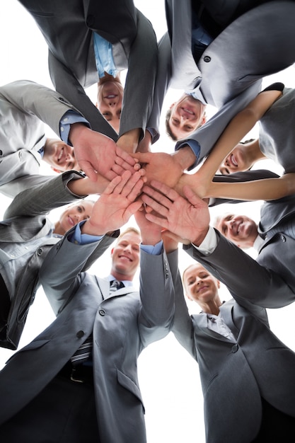 Foto sonriente equipo de negocios de pie en círculo manos juntas