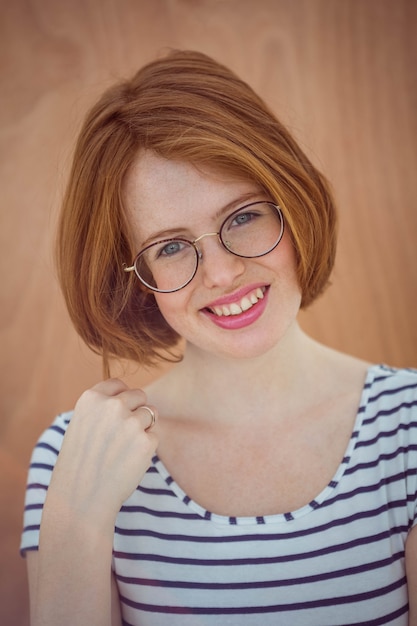 sonriente hipster con gafas en madera