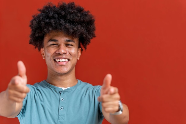 Sonriente hombre afroamericano mirando a la cámara aislada sobre fondo rojo Panamá América Central