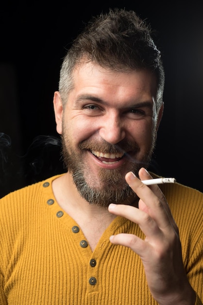 Sonriente hombre fumando cigarrillo Humo en negro