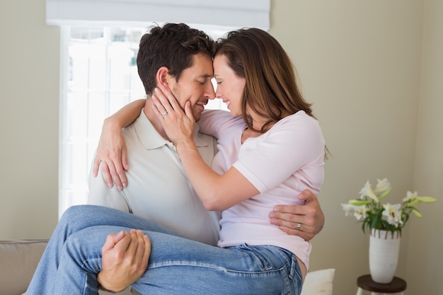 Sonriente hombre llevando a mujer