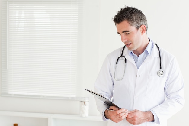 Sonriente hombre médico mirando una tabla