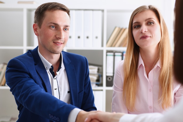 Sonriente hombre y mujer se dan la mano