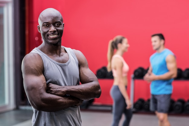 Sonriente hombre musculoso con los brazos cruzados