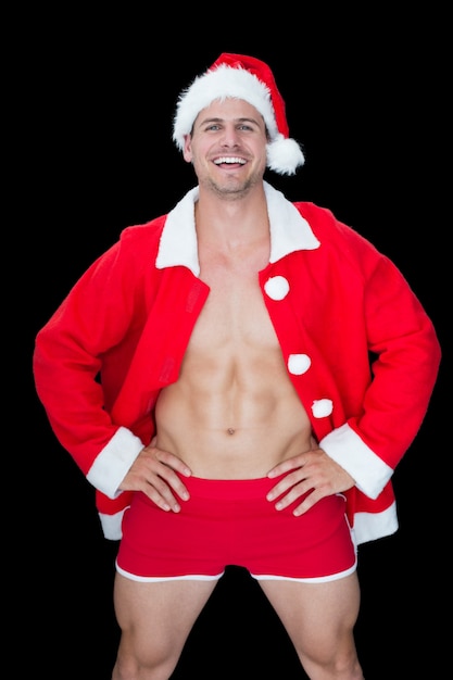 Sonriente hombre musculoso posando en sexy traje de santa