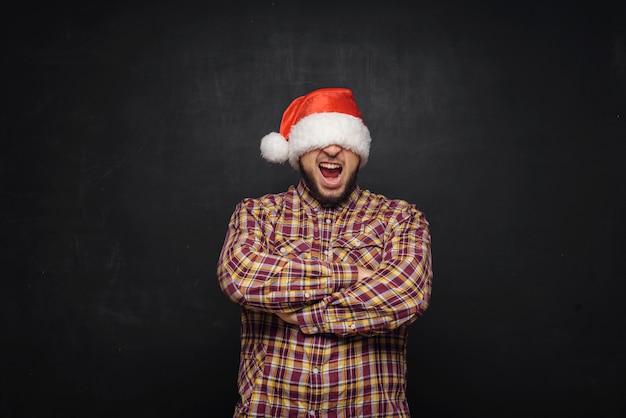 Sonriente hombre de Navidad con un gorro de Papá Noel aislado en negro