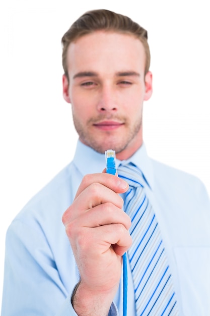 Sonriente hombre de negocios en camisa sosteniendo un cable sobre fondo blanco