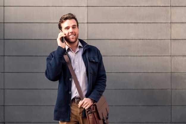 Sonriente hombre de negocios caucásico hablando por teléfono