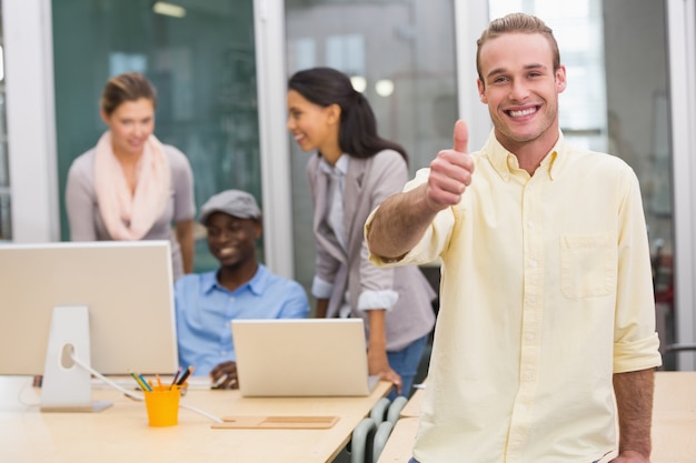 Sonriente hombre de negocios con colegas en la oficina