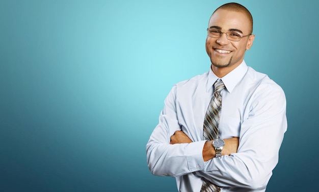 Sonriente hombre de negocios guapo con las manos cruzadas aislado en blanco