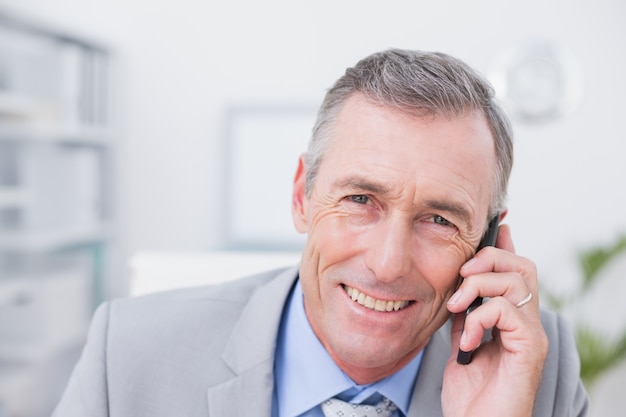 Sonriente hombre de negocios llamando a su escritorio