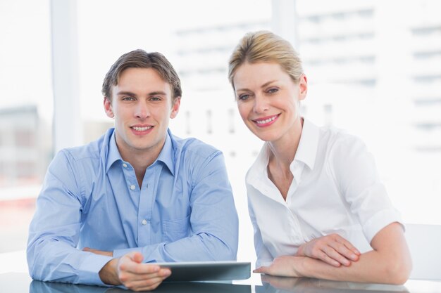 Sonriente hombre de negocios y la mujer en la oficina