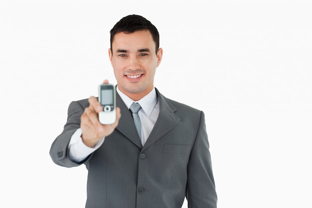 Sonriente hombre de negocios que muestra su teléfono