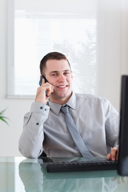 Sonriente hombre de negocios recibiendo buenas noticias en el teléfono celular