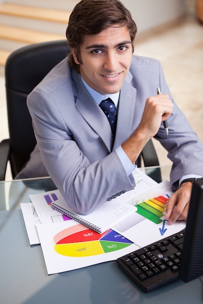 Sonriente hombre de negocios trabajando en estadísticas